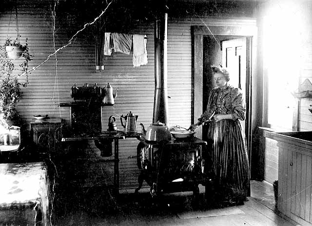 Photo of woman cooking at kitchen stove, 1890.