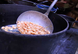 Photo of a ladle full of pork and beans.