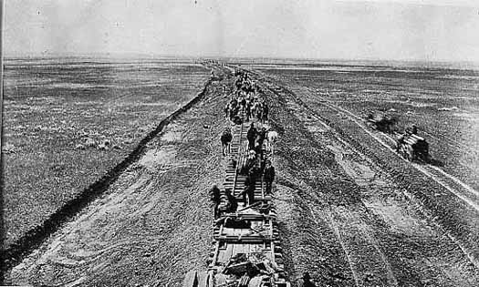 Photo of crew laying down a railroad line on the prairie, 1887.
