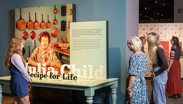 Visitors looking at the table at the Julia Child Exhibit.